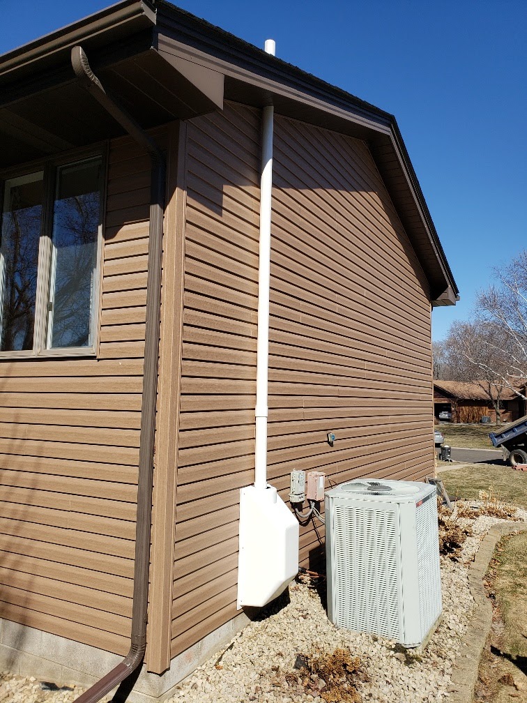 brown house with radon mitigation system on the side