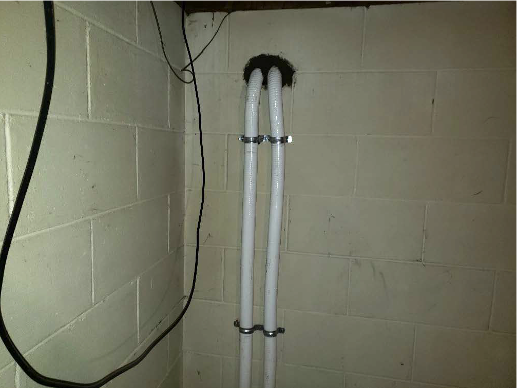 Two pipes sticking out of a wall.